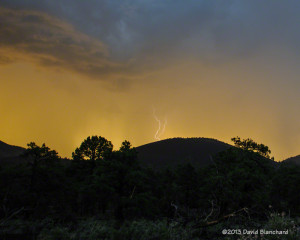 Lightning behind one of the many cinder hills in Sunset Crater National Monument.