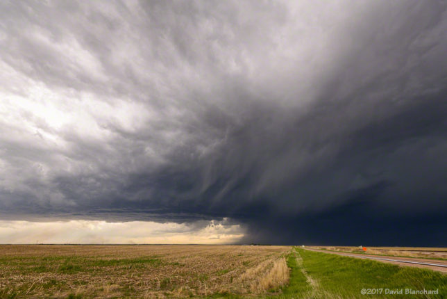 A supercell thunderstorm approaches from the southwest.