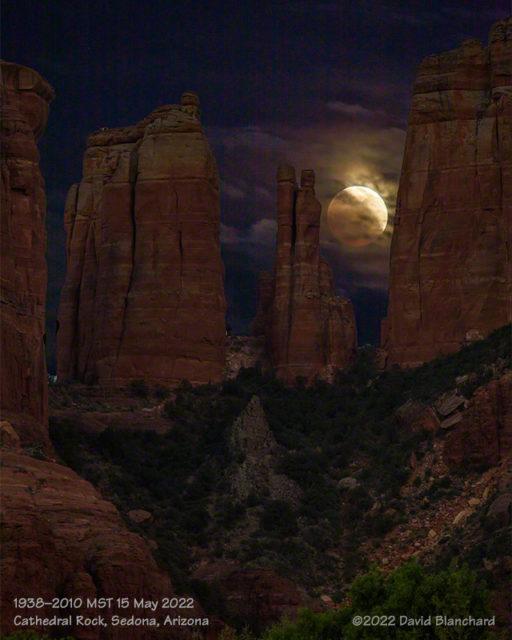A partially-eclipsed Moon rises behind Cathedral Rock.