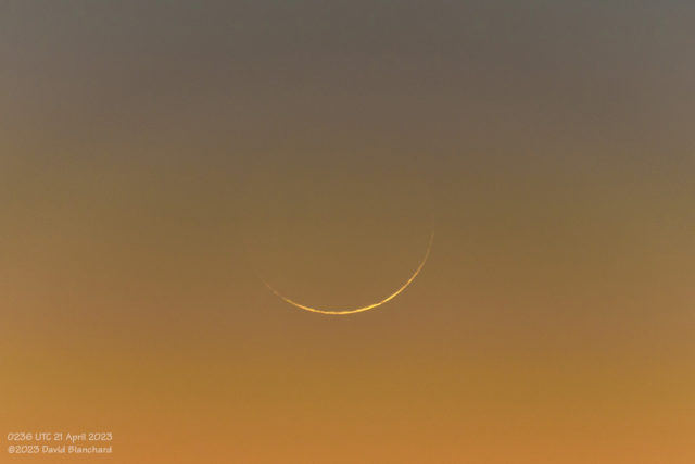 A thin crescent Moon visible in the evening twilight sky.