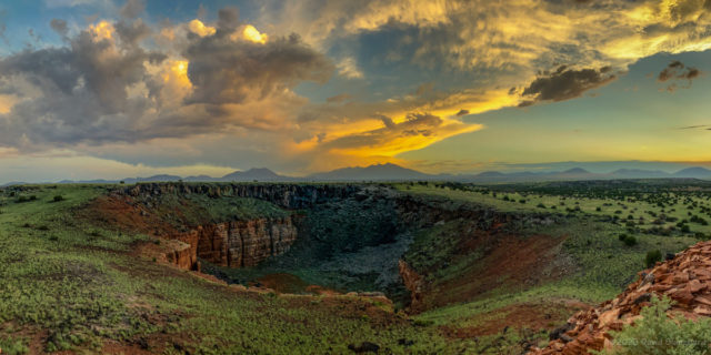 Panoramic view of sunset colors over the San Francisco Peaks from Wupatki National Monument. Citadel Sink is in the foreground.
