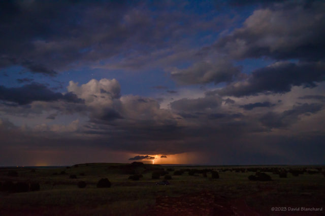Distant storm and lightning and stars looking over the grasslands of Wupatki National Monument.