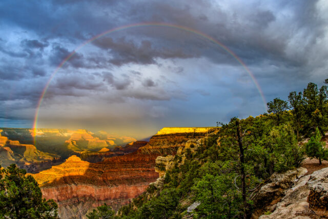 A rainbow moments before sunset spans the canyon.