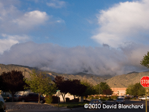 Clouds spilling across the top of the peaks of the Sandia Range