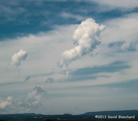Small funnel below an eroding cumulus tower.